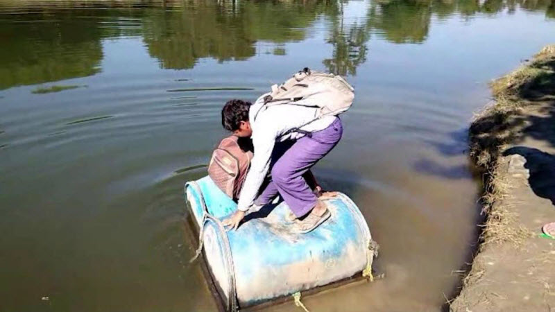 Индийские школьники вынуждены пересекать реку на пластиковых бочках