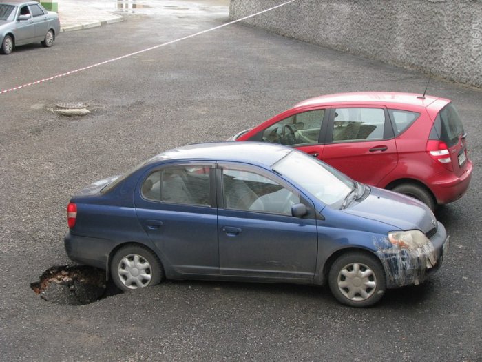 На парковке в асфальт провалились три машины