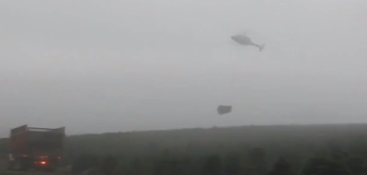 Вертолет грузит елки в грузовики!