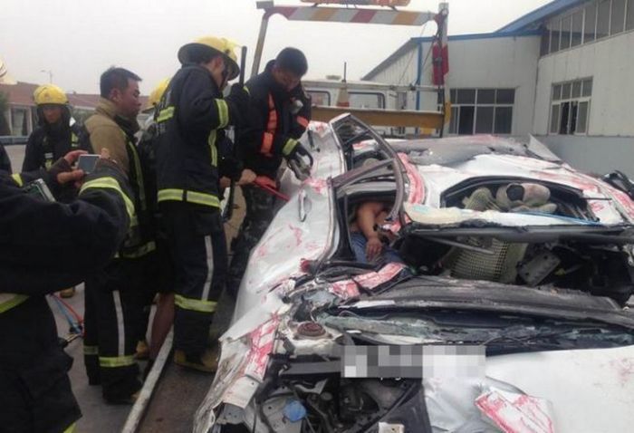 Машину раздавило контейнером